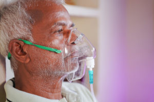 Close Up Head Shot Of Old Man Breathing On Ventilator Oxygen Mas